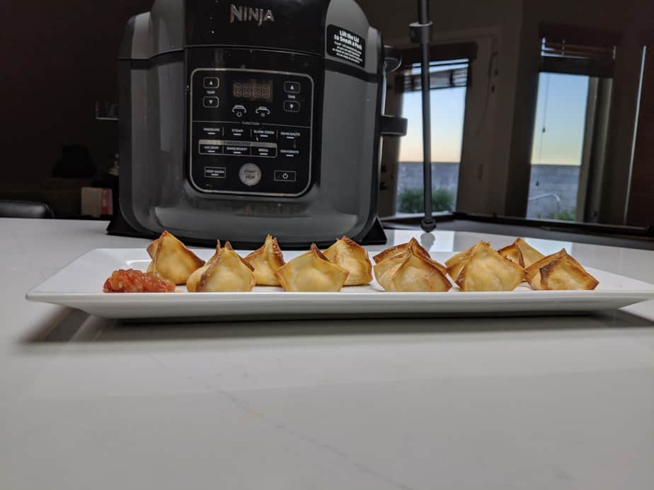 Buffalo Chicken Wontons with salsa in front of a Ninja Foodi