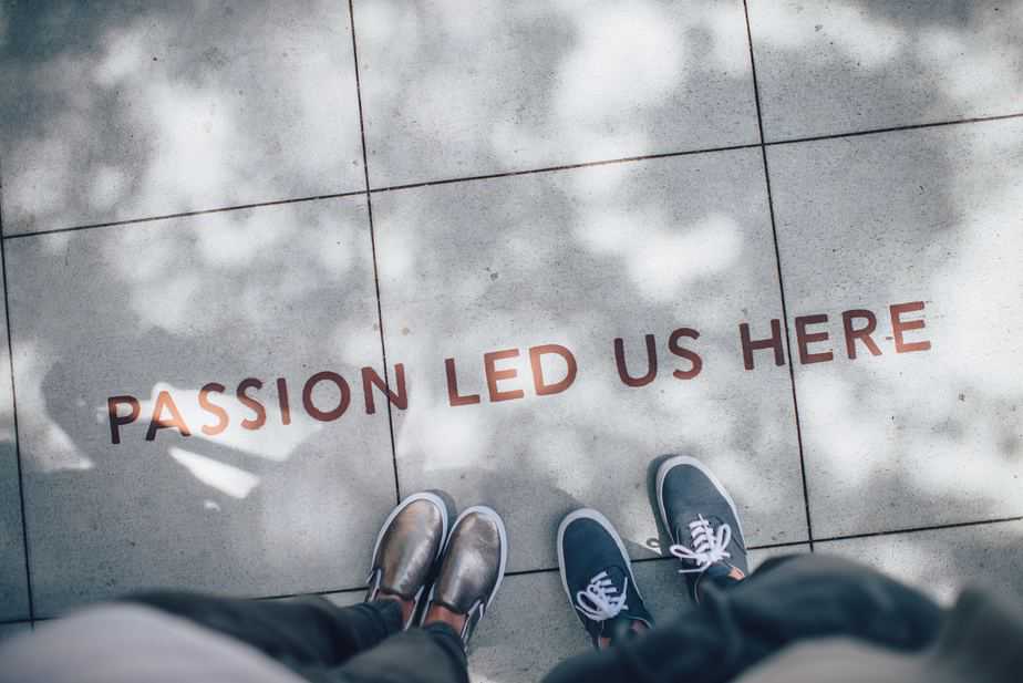 2 people standing on a sidewalk where there is written "Passion led us here"