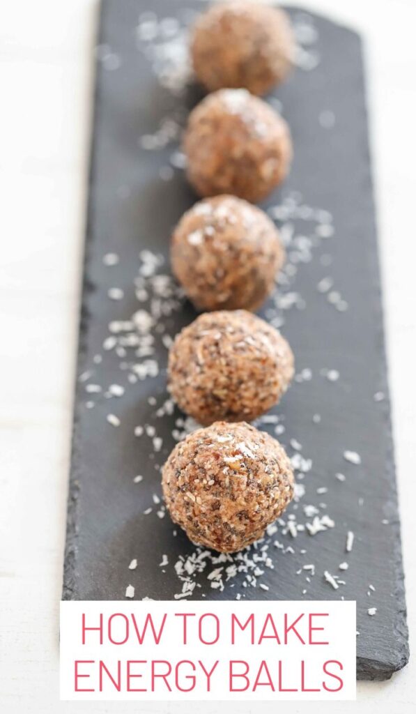 How to make protein balls. Focus is on one protein ball on a slate with coconut shaving surrounding it.