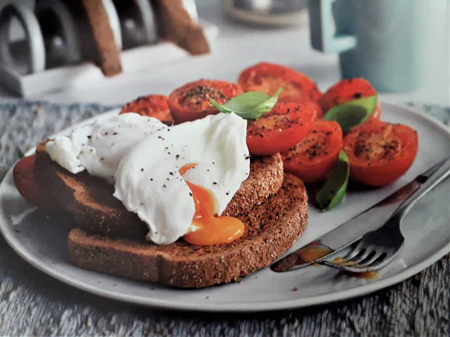 poached egg sandwich with tomatoes and whole grain bread