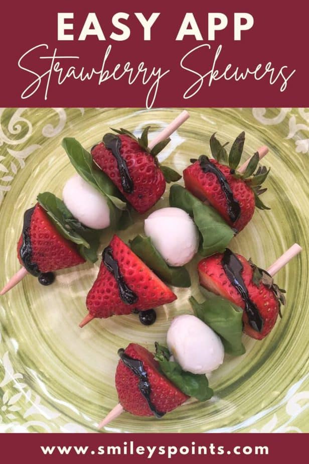 Three skewers with strawberries, basil, small balls of mozzarella cheese and a drizzle of balsamic glaze sit on a a green plate. 