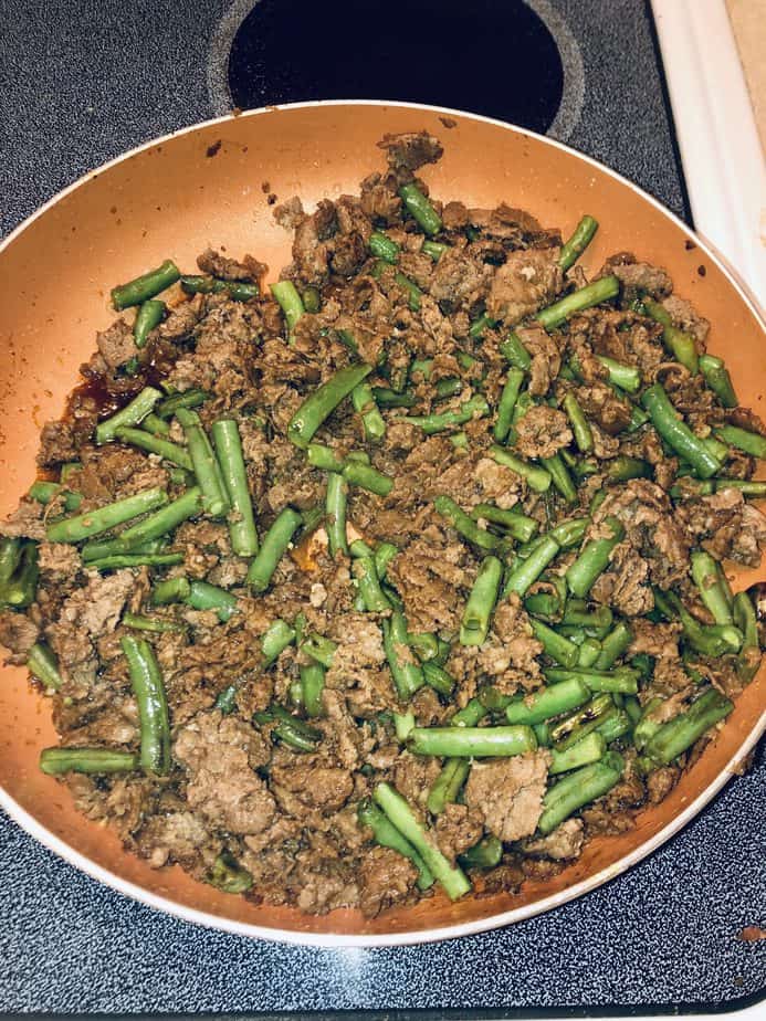 beef and green beans in a copper pan
