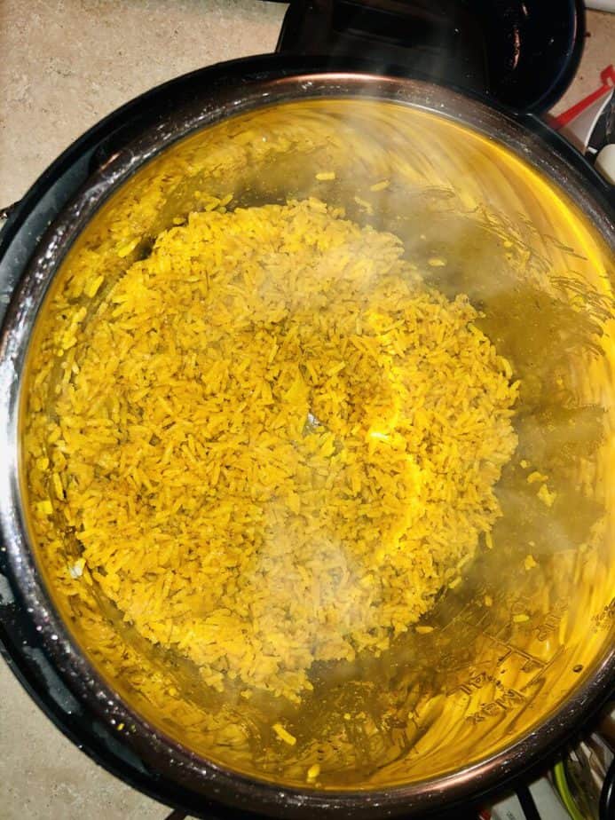Inside of an instant pot with yellow rice inside