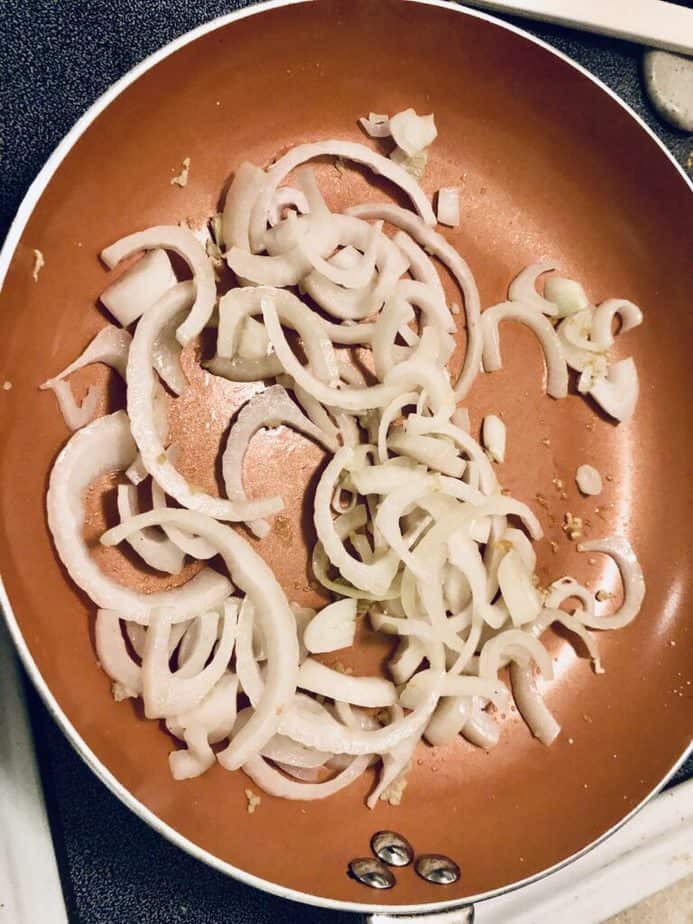 sliced onions and diced garlic in a copper skillet