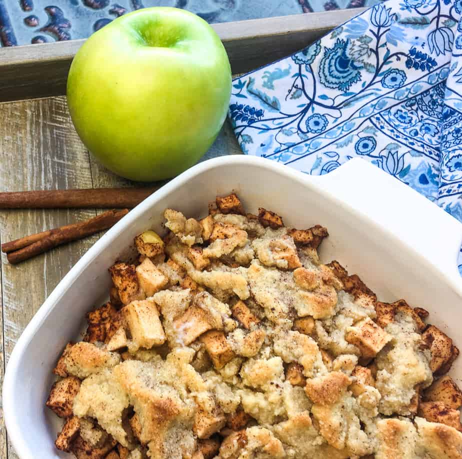 apples in a baking dish with a green apple on the side of the dish