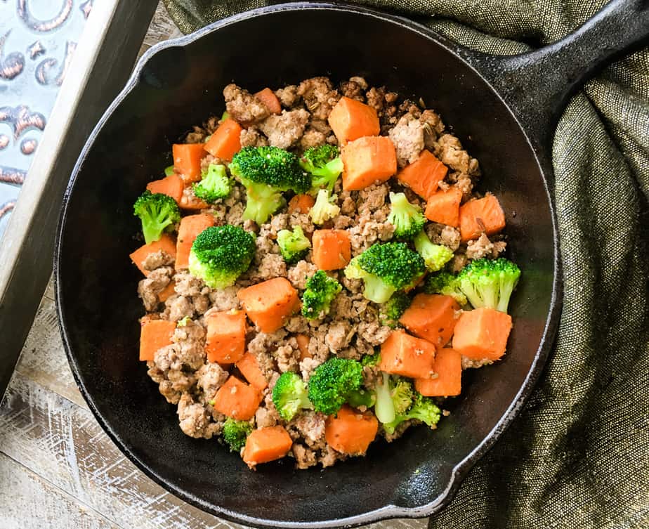 turkey sausage with sweet potatoes and broccoli in a cast iron skillet 