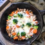 turkey sausage with sweet potatoes and broccoli in a cast iron skillet with melted mozzarella cheese