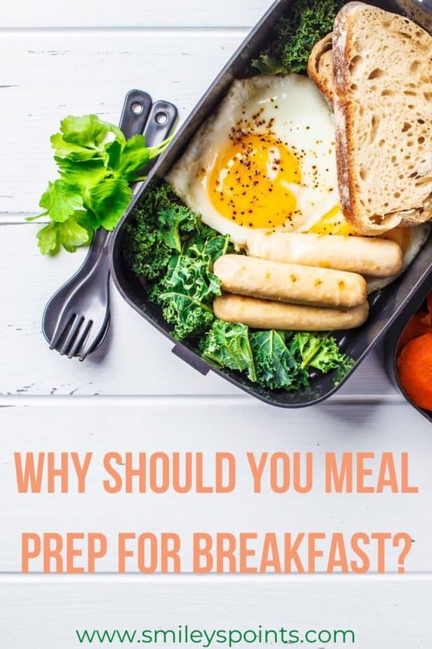Meal Prep A black container with salad, toast and a sunny-side up egg in it. It sits on a white wooden table with a fork next to the container and greens next to that