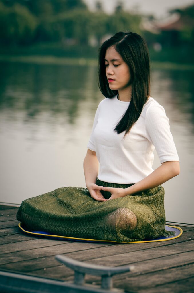 box breathing woman sitting lotus style with her eyes closed