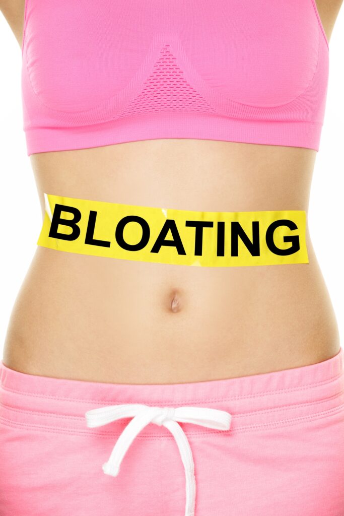woman with 'bloating' written on her stomach