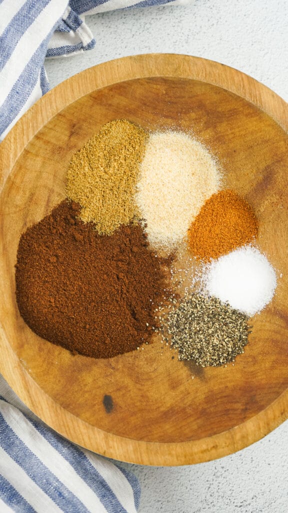 chili  spice seasonings not mixed up yet in a wooden bowl.