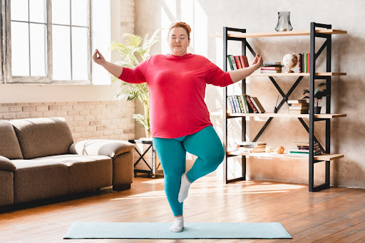 Woman plus size in gym doing exercises with running training