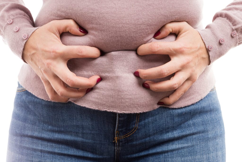 woman grabbing her belly as painful abdominal problem because of bloated tummy or premenstrual pain