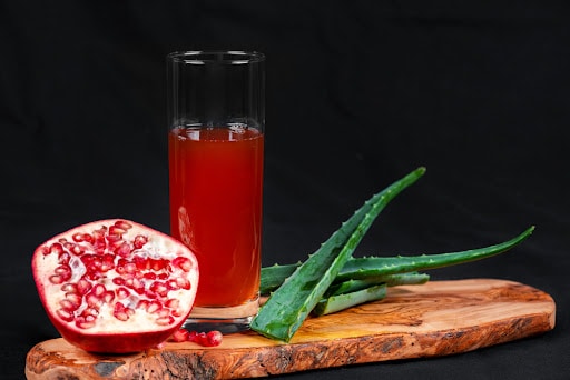 Delicious aloe vera pomegranate juice served on a wooden board