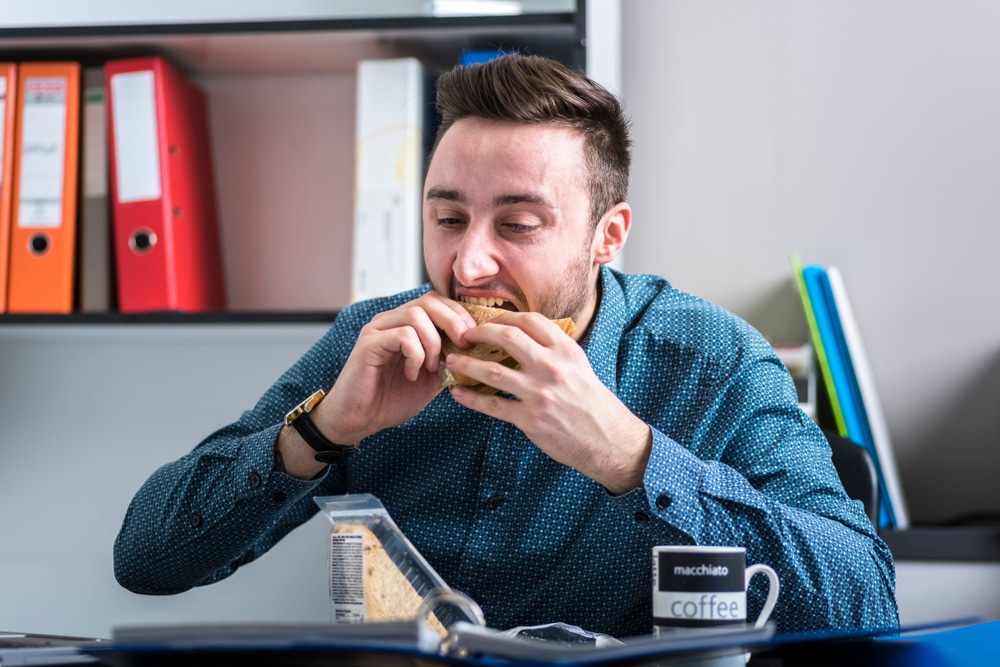 Hungry man eating In the office quickly