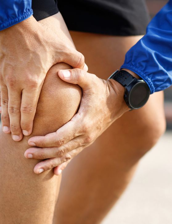 Close-up of a man suffering from knee pain while exercising outdoors