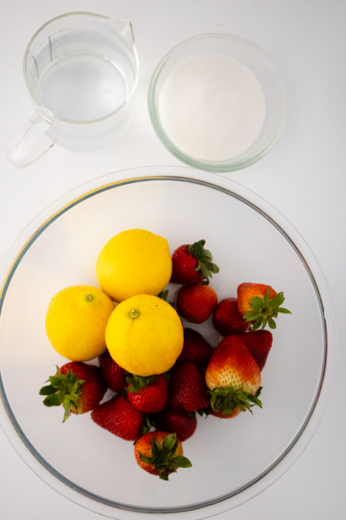 Fresh lemon and strawberries inside the glass bowl