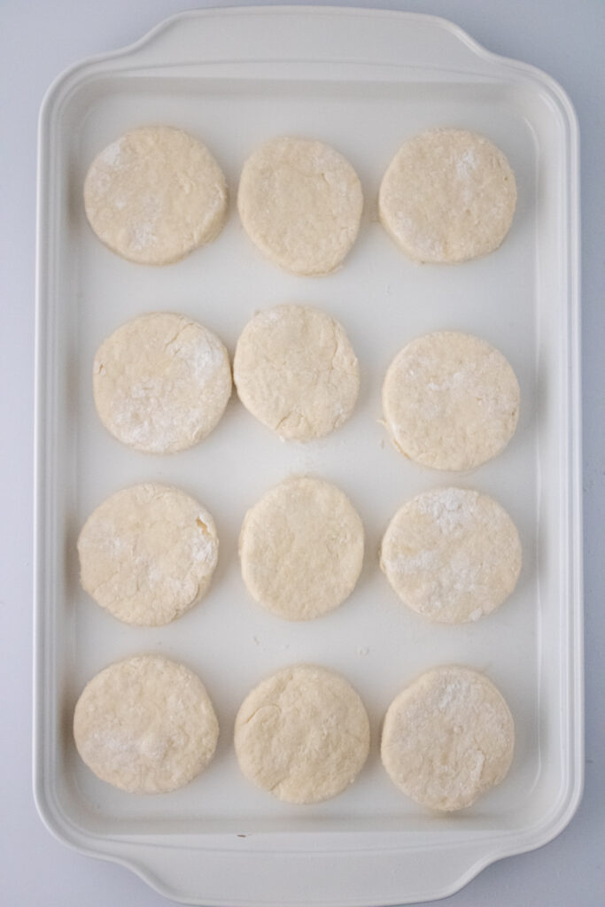 cut dough pieces placed on a white baking plate