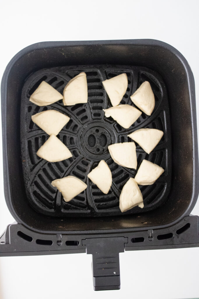 cut pieces of grands biscuit pieces placed in air fryer pan