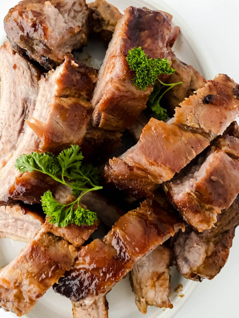 cut pieces of oven baked baby back rib with coriander leaves