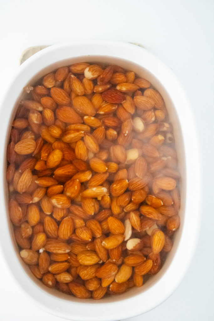 raw almonds soaked in hot water inside the bowl