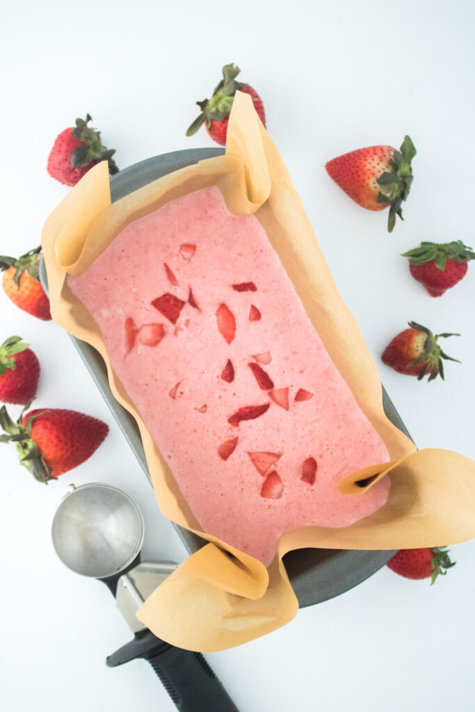 frozen strawberry ice-cream in the loaf pan along with fresh strawberries and scoop
