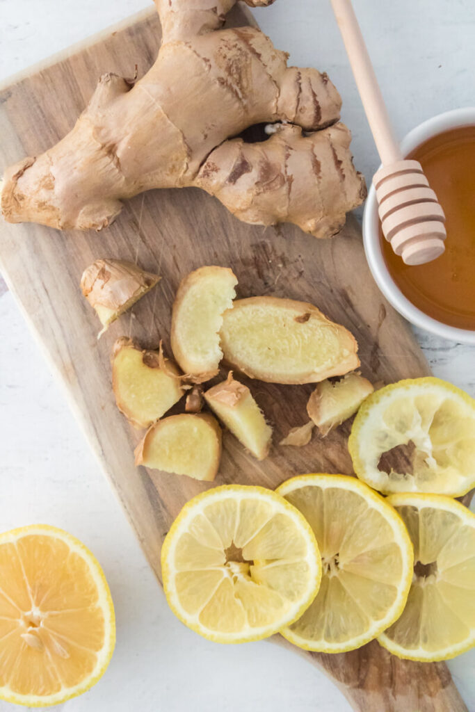sliced ginger and lemon pieces along with honey in a small cup