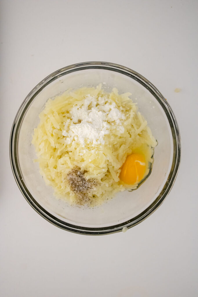 mix of boiled grated potatoes, egg, salt, pepper and corn starch in large bowl
