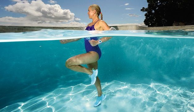 A woman performs underwater exercises in a pool, showcasing both surface and underwater views, wearing a swimsuit and water shoes